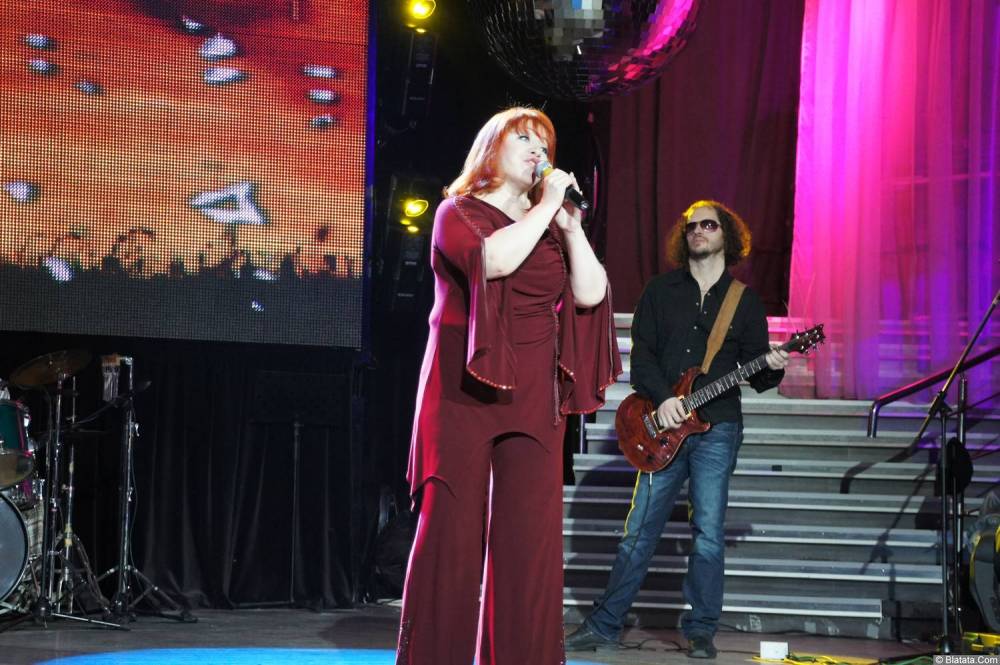Олеся Атланова с микрофоном на концерте 2013 года