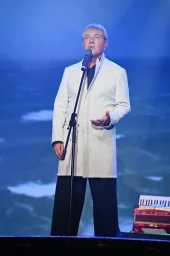 Сергей Рогожин с легкой улыбкой смотрит в зал