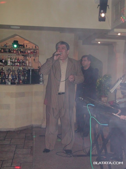 Бока Давидян с микрофоном на сцене ресторана поёт