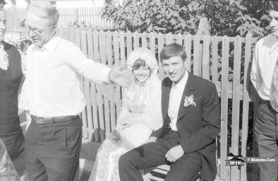 Жених с невестой сидят на деревенской лавочке